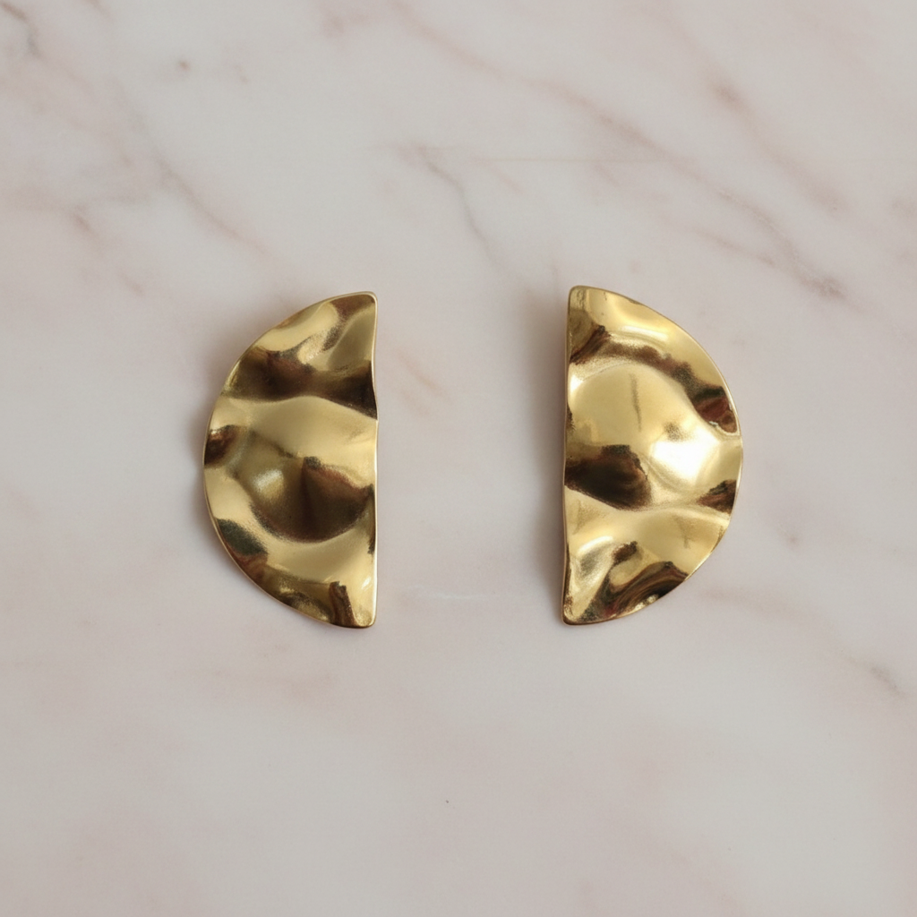 Gold half moon earrings on blush marble