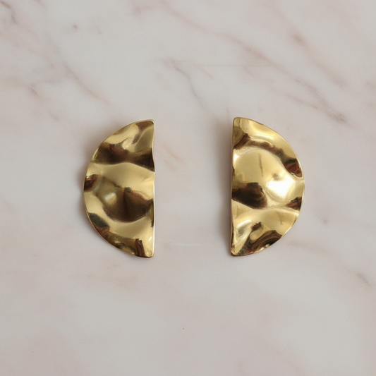 Gold half moon earrings on blush marble