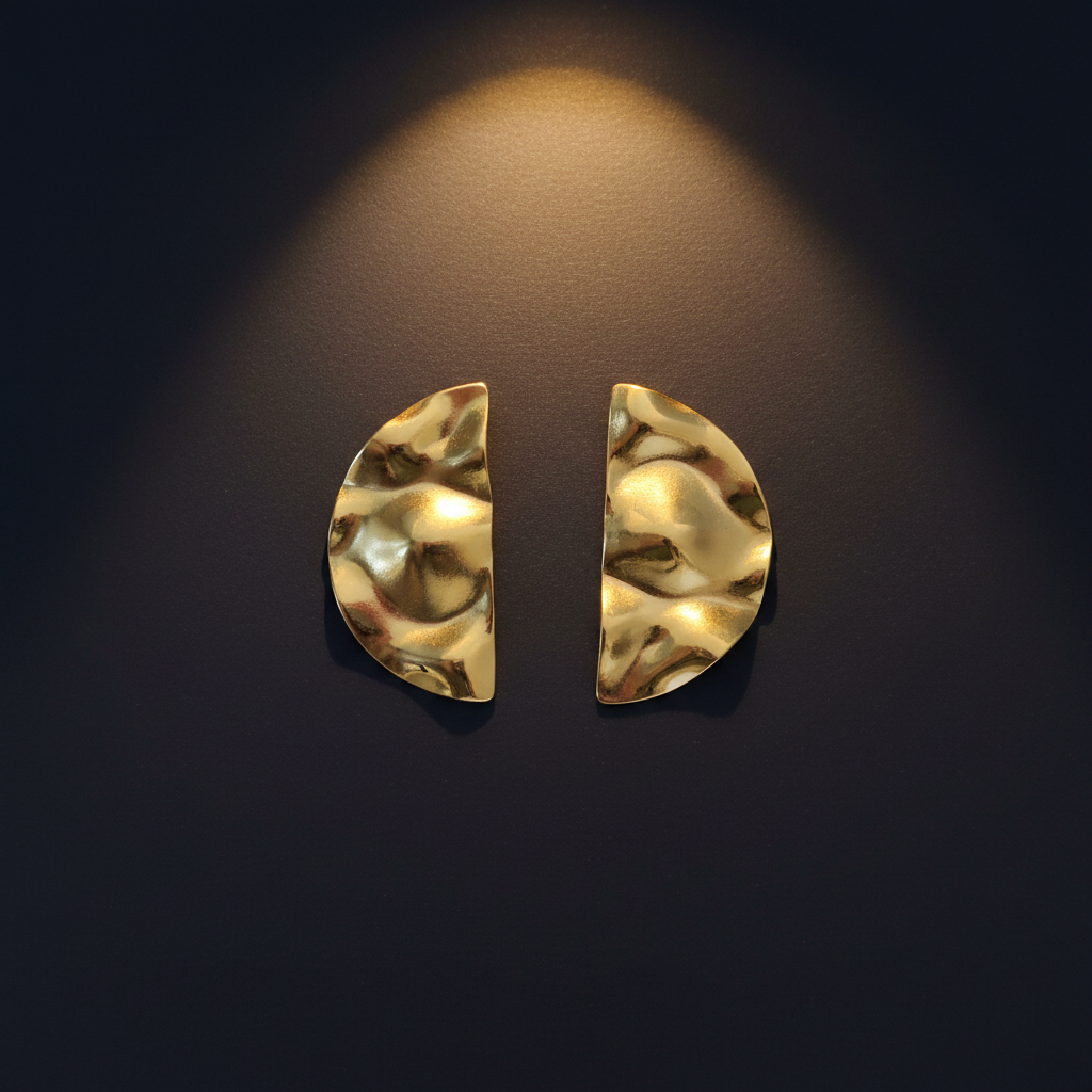 Gold half moon earrings on navy surface