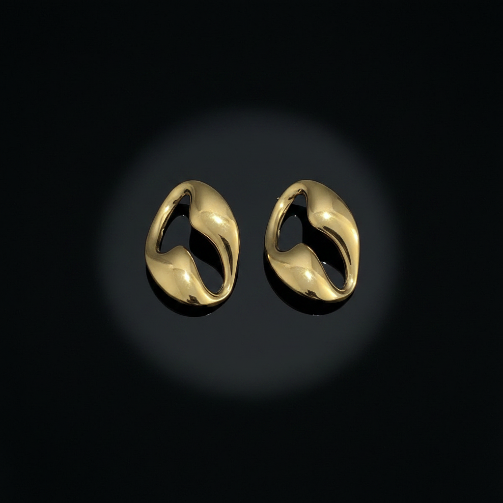 Gold oval hoop earrings on black lacquer
