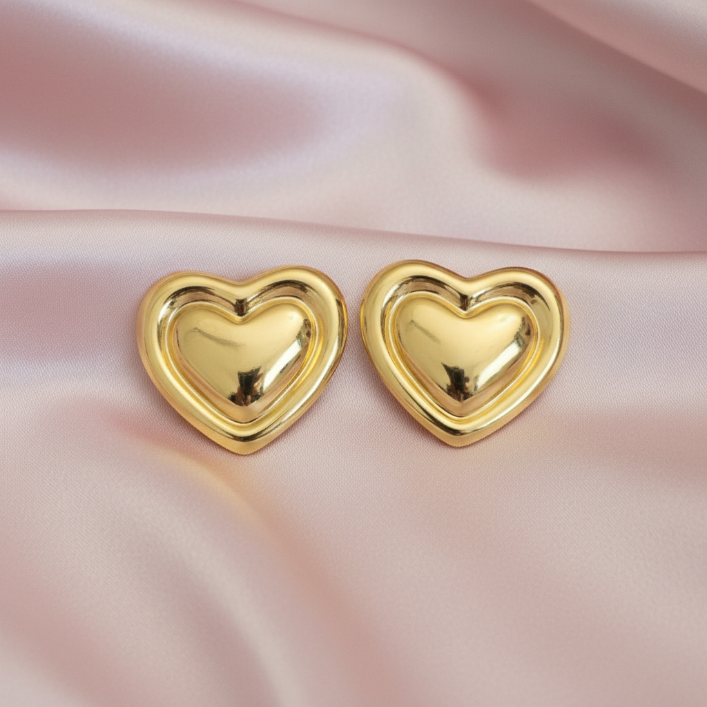 Gold puffy heart studs on blush satin
